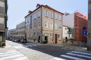 un gran edificio de ladrillo en una calle de la ciudad en Refreshing Cozy Flat - Garden & Terrace, en Oporto