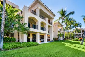 a large building with palm trees and a yard at The Shores at Waikoloa 114 in Waikoloa