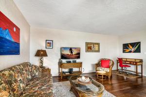 a living room with a couch and a table at Alii Villas 309 in Kailua-Kona