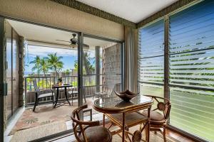 a screened in porch with a table and chairs at Alii Villas 309 in Kailua-Kona