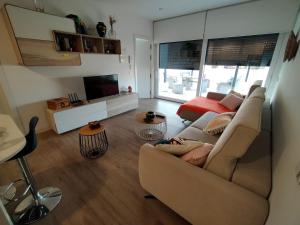 een woonkamer met een bank en een tv bij Ático los cocones in Carboneras