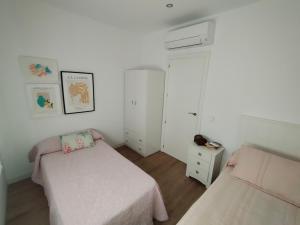 a small bedroom with two beds and a window at Ático los cocones in Carboneras