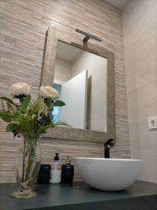 een badkamer met een wastafel en een spiegel bij Ático los cocones in Carboneras