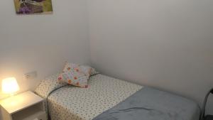 a small bedroom with a bed and a lamp at MAR Y PLAYA in A Guarda