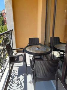 a patio with tables and chairs on a balcony at Villa Astoria 5. Sveti Vlas k.k. Elenite in Sveti Vlas