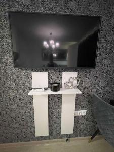 a white table with a television on a wall at Villa Astoria 5. Sveti Vlas k.k. Elenite in Sveti Vlas