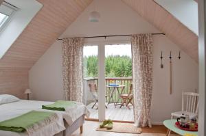 um quarto com uma cama e uma varanda em Escape to PaulssonPaleo em Simlångsdalen
