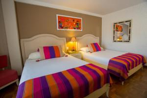 a bedroom with two beds with colorful striped sheets at Hotel Rosario La Paz in La Paz