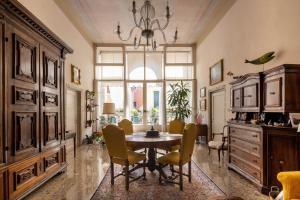 uma sala de jantar com uma mesa e cadeiras e um lustre em Campiello Zen B&B em Veneza
