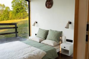 1 dormitorio con cama y ventana grande en Domek z sauną Neptun en Krzyżowa