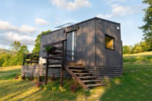 ein kleines Holzhaus auf einem Feld mit einer Leiter in der Unterkunft Domek z sauną Neptun in Kreisau