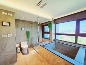 a bathroom with a tub and a toilet and a shower at 文旅海景 in Toucheng