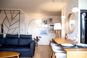 een woonkamer met een blauwe bank en een tafel bij Bright nest with balcony ideal for a couple in Bordeaux