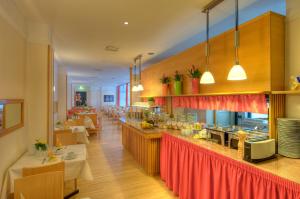a restaurant with a counter with tables and chairs at Dürer-Hotel in Nuremberg