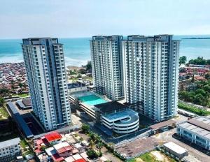 une vue aérienne sur une ville avec de grands bâtiments et l'océan dans l'établissement Borneo Cove Seaview Sandakan, à Sandakan