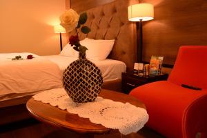 una habitación de hotel con un jarrón con una flor en una mesa en Hotel La Farola en Cuenca