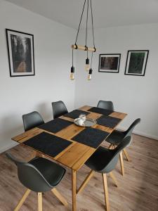 a dining room with a wooden table and chairs at Deisterquartier, Ferienwohnung am Naherholungsgebiet in Barsinghausen
