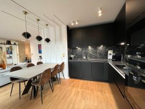 a kitchen and dining room with a table and chairs at Appartement Luxueux climatisé avec Terrasse, 6 couchages - 17ème Arrondissement de Paris in Clichy