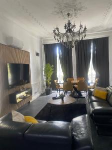 a living room with a black leather couch and a table at Pyramide in Mulhouse