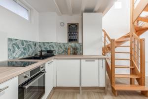 une cuisine avec des placards blancs et un escalier dans l'établissement Beautiful flat in the heart of Lyon - Welkeys, à Lyon