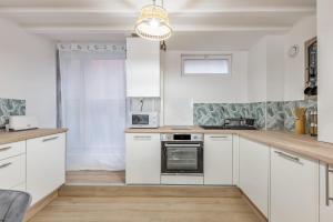 a kitchen with white cabinets and a chandelier at Beautiful flat in the heart of Lyon - Welkeys in Lyon