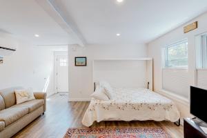 um quarto branco com uma cama e um sofá em Shorelands 44-1 em Kennebunk