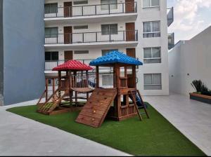 un parque infantil con dos estructuras de juego en un césped en Comfort Flat In Guadalajara, en Guadalajara