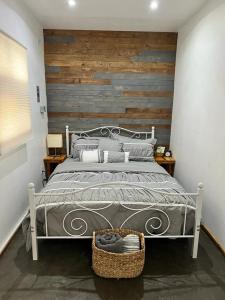 ein Schlafzimmer mit einem großen Bett und einer Holzwand in der Unterkunft Heart of Ruta Del Vino, Cozy Casitas Pan y Vino! in Valle de Guadalupe