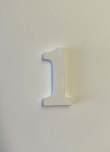 a white number one hanging on a wall at Iblu Rooms in Termoli