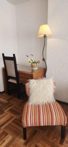 um quarto com uma cadeira e uma mesa com um candeeiro em Ambar apartamento em Mar del Plata