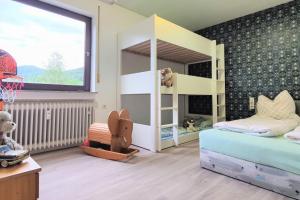 - une chambre pour enfants avec des lits superposés et un panier de basket dans l'établissement Familien-Ferienwohnung Lichtenstein (BW), à Lichtenstein