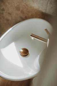 a close up of a toilet bowl with a gold flushbutton at LASpot Szafarnia in Szafarnia