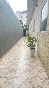 a sidewalk with a plant in a pot next to a building at GL Pousada in Guarujá