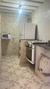 uma cozinha com um fogão e um frigorífico em GL Pousada no Guarujá