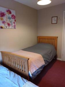 a bedroom with two beds and a painting on the wall at Detached Country Bungalow in Wroughton