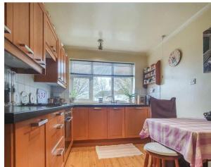 a kitchen with wooden cabinets and a table and a window at Detached Country Bungalow in Wroughton