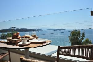 a table on a balcony with a view of the water at Salty Wave Suites in Skiathos Town