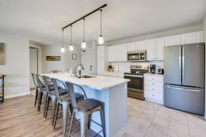 a kitchen with white cabinets and a kitchen island with bar stools at Lakefront Birchwood Condo with Pool and Hot Tub! in Birchwood