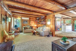 a living room with wooden walls and a wooden ceiling at Rustic Bandon Log Cabin on 5 Acres of Woodlands! in Bandon
