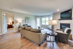un soggiorno con divano e camino di Lakefront Birchwood Condo with Pool and Hot Tub! a Birchwood
