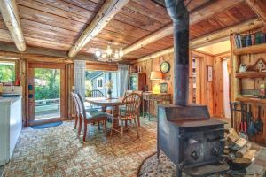 a kitchen and dining room with a wood stove at Rustic Bandon Log Cabin on 5 Acres of Woodlands! in Bandon