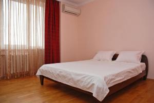 キーウにあるKiev Pozniaky Apartmentのベッドルーム1室(白いシーツ付きのベッド1台、窓付)