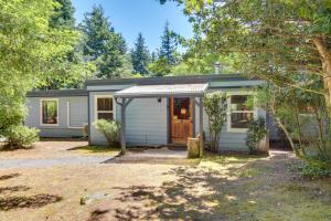 a small white shed with a door in a yard at Rustic Bandon Log Cabin on 5 Acres of Woodlands! in Bandon