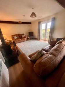 a living room with a couch and a large window at Braffin @ Fellside Farm, Pennington, Ulverston in Pennington