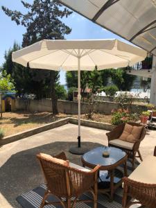 patio con tavolo, sedie e ombrellone di Sea Front Retreat a Kavala