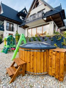een achtertuin met een hot tub en een speeltuin bij Domki Widokowelove in Gliczarów