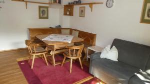sala de estar con mesa y sofá en Ferienwohnung Dillmann en Sachrang
