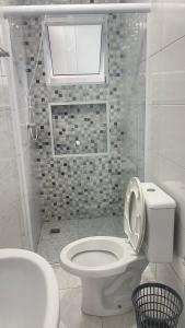 Baño blanco con aseo y lavamanos en GL Pousada en Guarujá