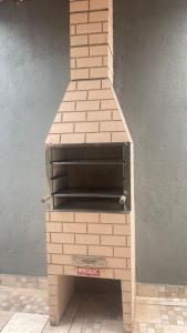 um forno de pizza de tijolo sentado em cima de uma parede em GL Pousada no Guarujá