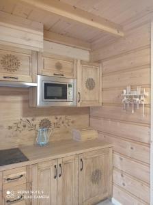 a kitchen with wooden cabinets and a microwave at Domki ,,Goramiba'' in Jurgów